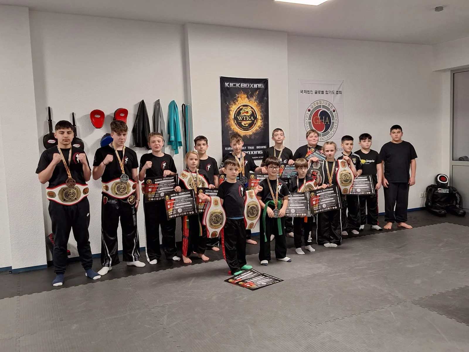 Nachwuchssportler der Akademie mit Gürteln, Urkunden und Preisen