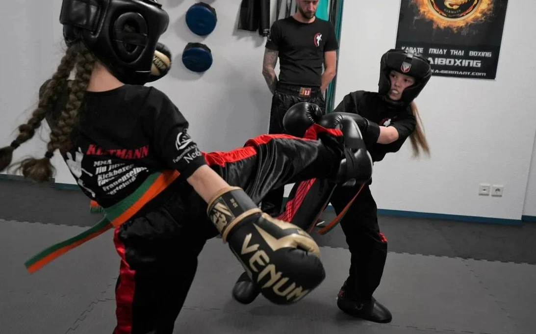 Zwei junge Sportlerinnen beim Kickboxtraining in der Akademie